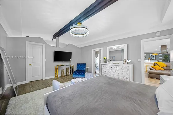 a bedroom with furniture and a flat screen tv