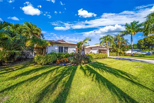 a front view of a house with a yard and potted plants