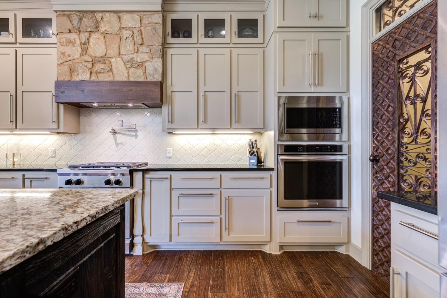 4808 115th Street Lubbock, TX 79424 - Photo 11 of 50 a kitchen with granite countertop a stove and a wooden floor