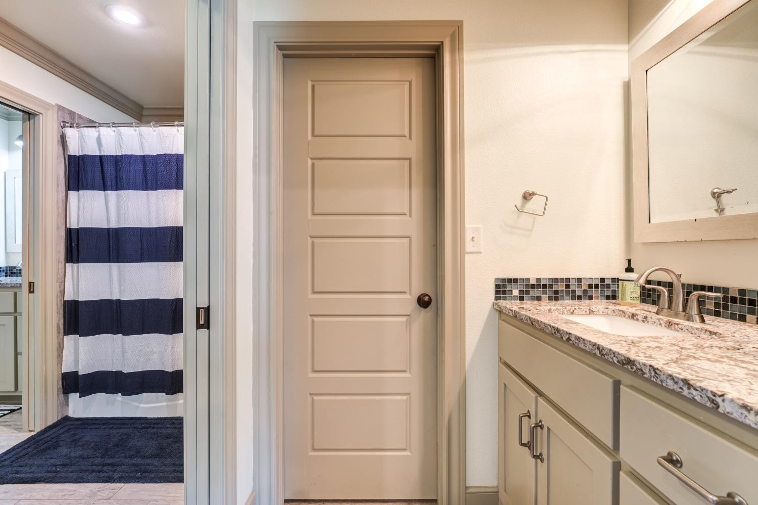 4808 115th Street Lubbock, TX 79424 - Photo 23 of 50 a bathroom with a granite countertop sink and a mirror