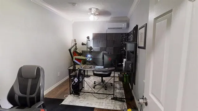 a view of a workspace with furniture and a fan