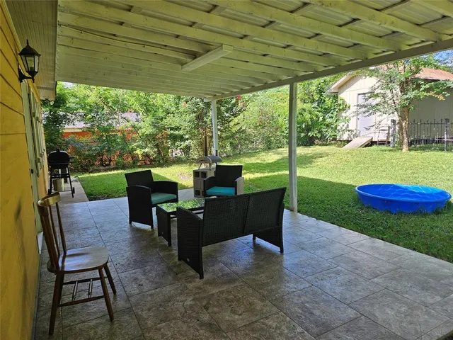 a view of a patio with a table chairs and a yard