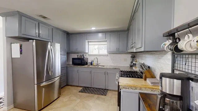 a kitchen with stainless steel appliances granite countertop a refrigerator sink and stove