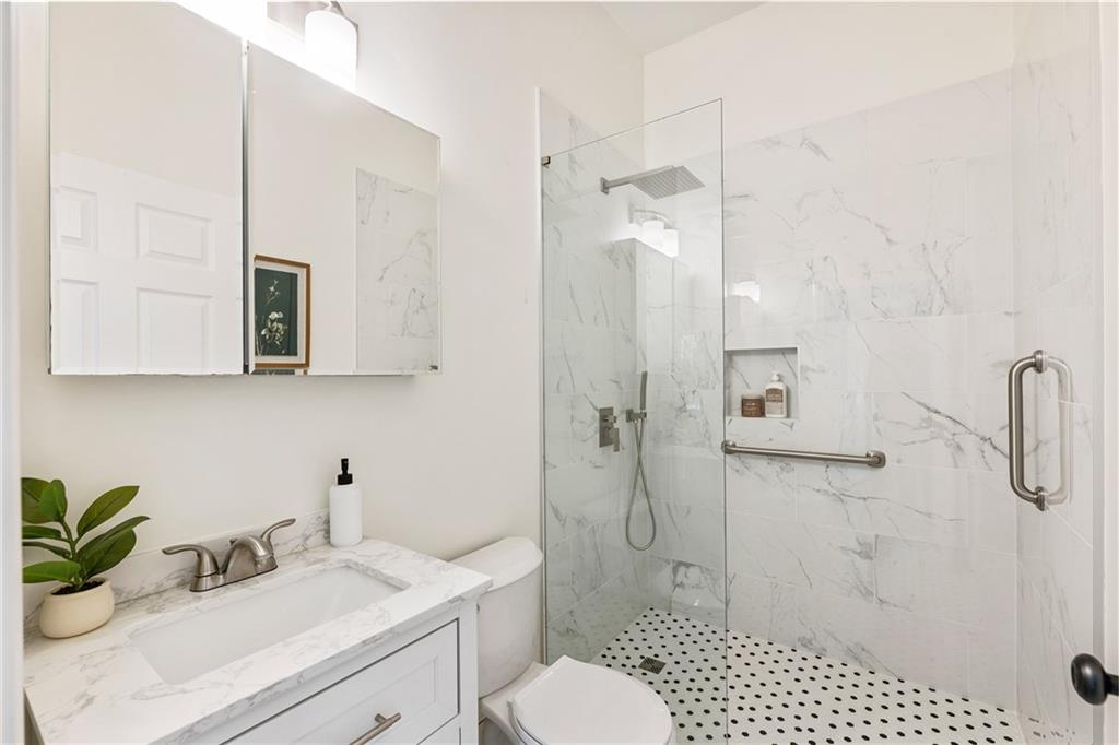 14440 Cogburn Road Alpharetta, GA 30004 - Photo 23 of 62 a bathroom with a sink toilet a mirror and shower