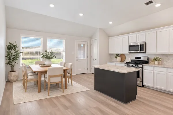 a kitchen with kitchen island a sink table and chairs