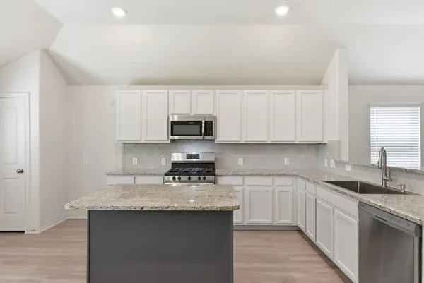 a kitchen with stainless steel appliances granite countertop a sink stove microwave and cabinets