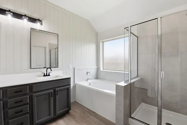a bathroom with a tub sink and mirror