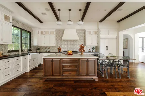 a kitchen with stainless steel appliances granite countertop a lot of counter space and wooden floors