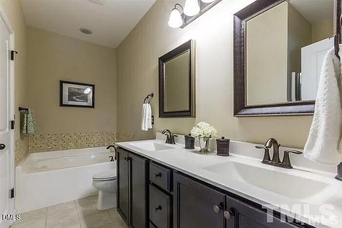 2436 Baslow Drive Apex, NC 27539 - Photo 14 of 21 a bathroom with a sink double vanity granite toilet tub and shower