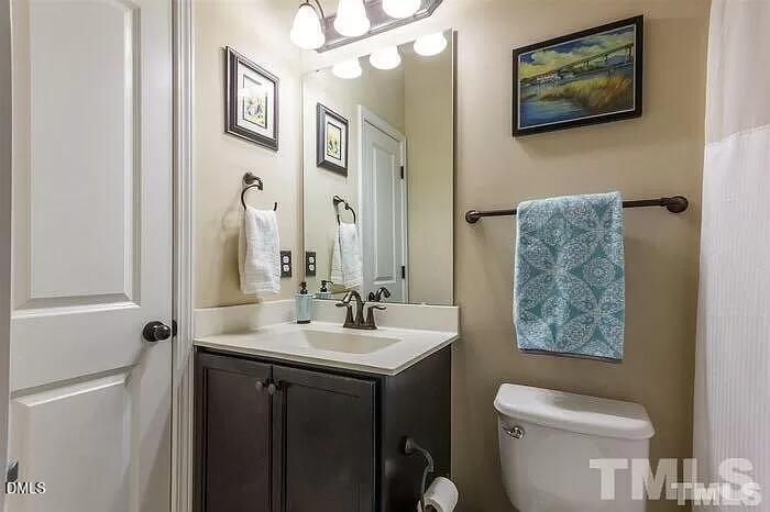 2436 Baslow Drive Apex, NC 27539 - Photo 18 of 21 a bathroom with a toilet a sink and a mirror