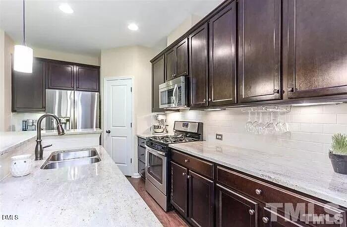 2436 Baslow Drive Apex, NC 27539 - Photo 6 of 21 a kitchen with stainless steel appliances granite countertop a sink stove and cabinets