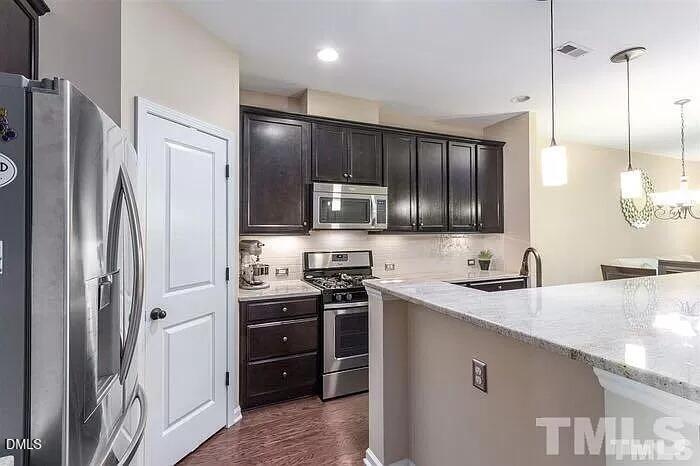 2436 Baslow Drive Apex, NC 27539 - Photo 7 of 21 a kitchen with stainless steel appliances granite countertop a refrigerator stove and sink