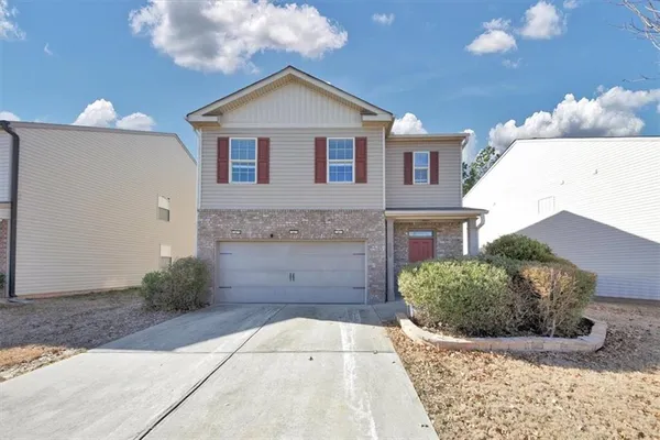 a front view of a house with a yard and garage