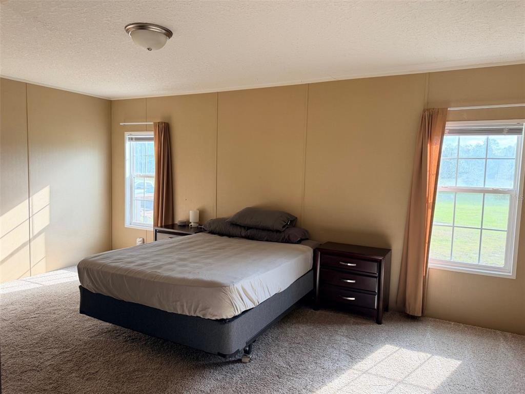 10730 198th Terrace O'Brien, FL 32071 - Photo 13 of 29 a spacious bedroom with a bed and a window