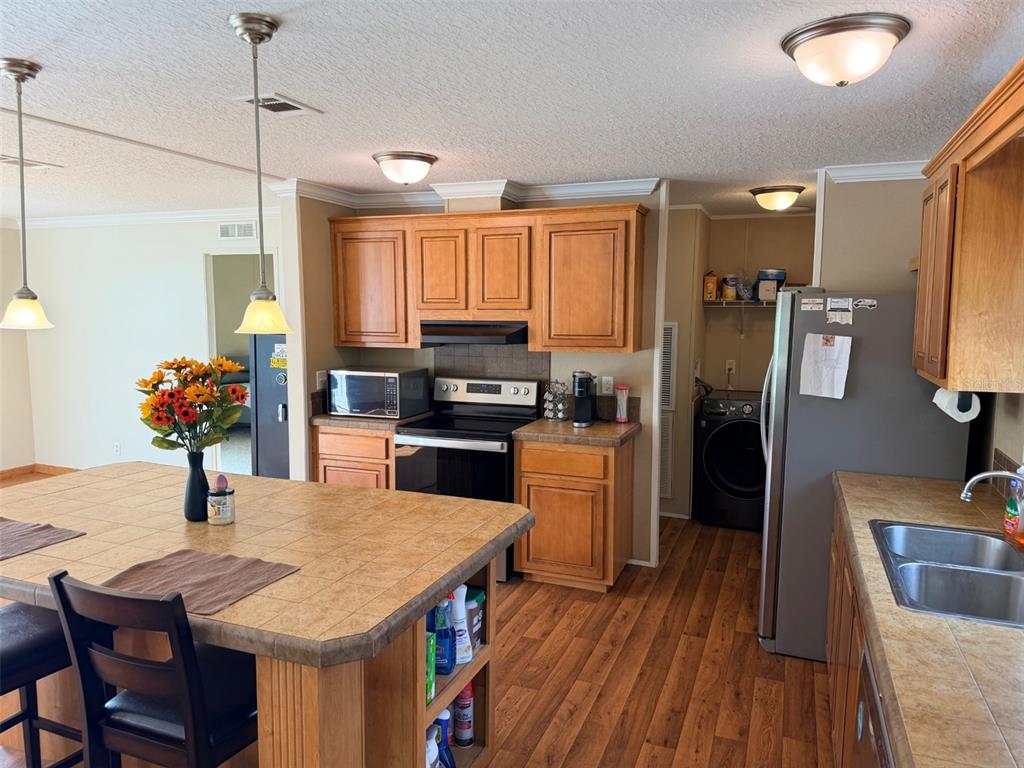 10730 198th Terrace O'Brien, FL 32071 - Photo 9 of 29 a kitchen with stainless steel appliances granite countertop a refrigerator a stove top oven a sink dishwasher and white cabinets with wooden floor