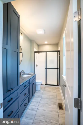 a bathroom with a sink a toilet and shower