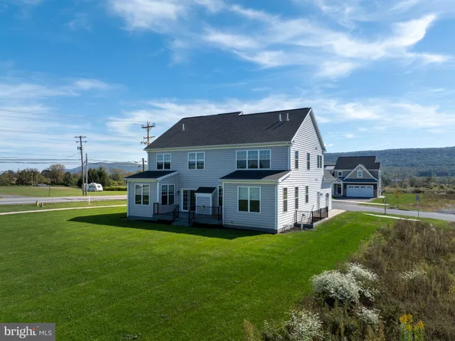 a kitchen with stainless steel appliances kitchen island granite countertop a stove a sink and white cabinets with wooden floor