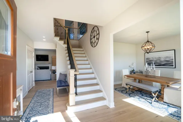 a kitchen with stainless steel appliances a dining table chairs refrigerator and microwave