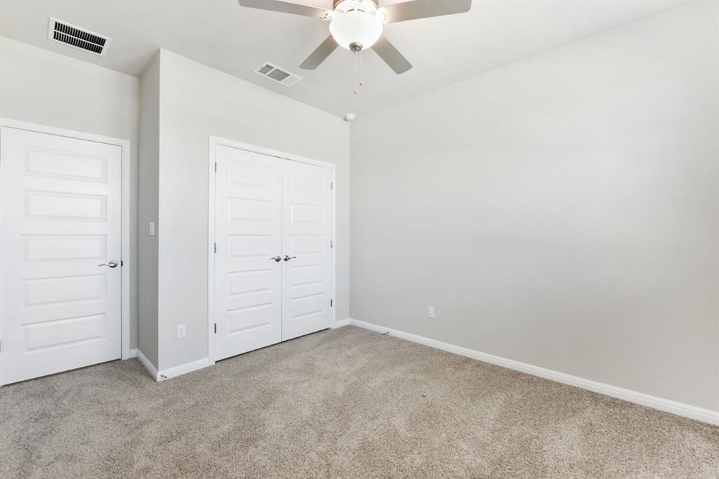 181 Old Town Road Kyle, TX 78640 - Photo 22 of 32 Plush carpeting and crisp white trim enhance this versatile bedroom space.