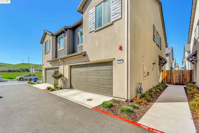 a view of a house with many windows and small yard