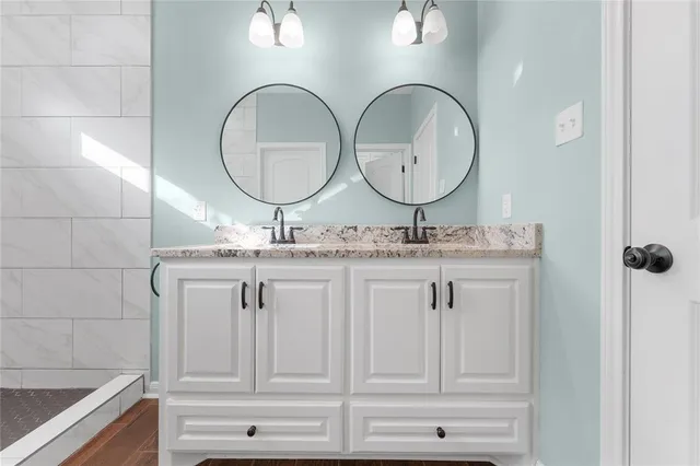 a bathroom with double vanity sink and a mirror