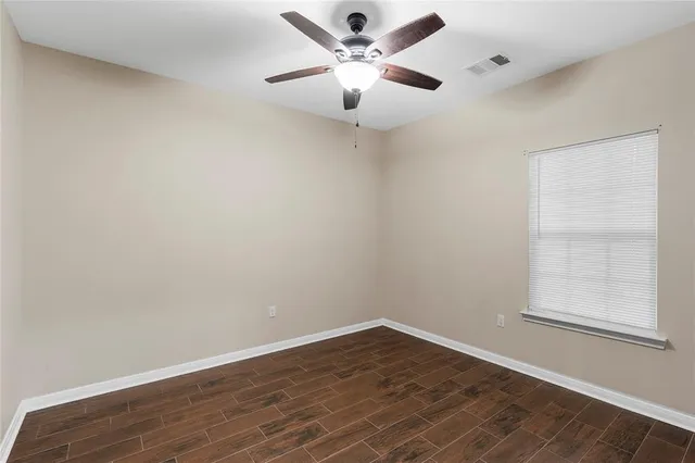 an empty room with a window and a ceiling fan