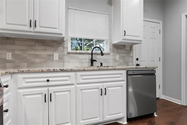 a kitchen with white cabinets and a sink