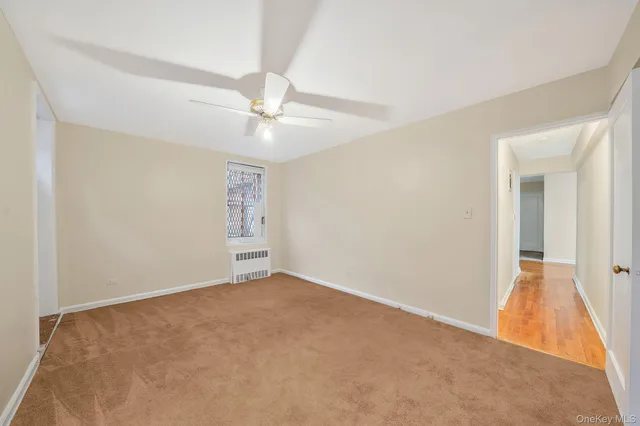 an empty room with fan and windows