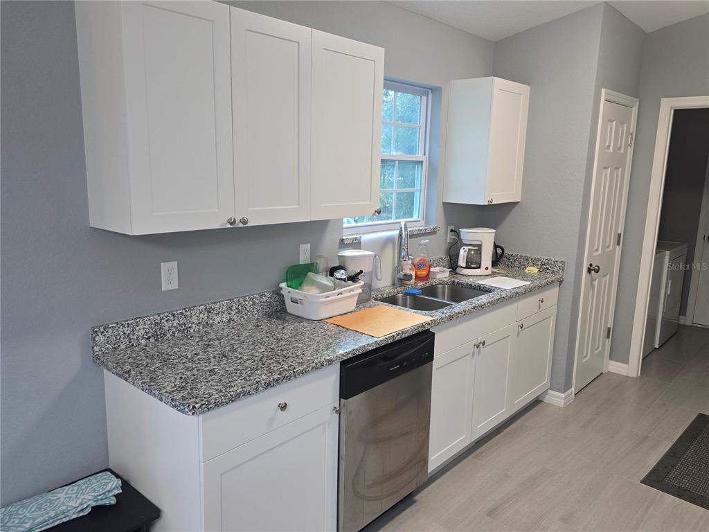 838 Northwest 124th Street Citra, FL 32113 - Photo 11 of 27 a kitchen with stainless steel appliances granite countertop a sink stove and cabinets