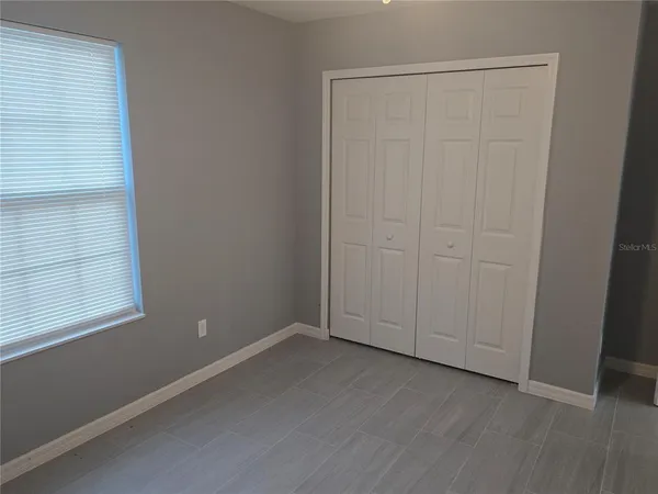 an empty room with wooden floor and closet area