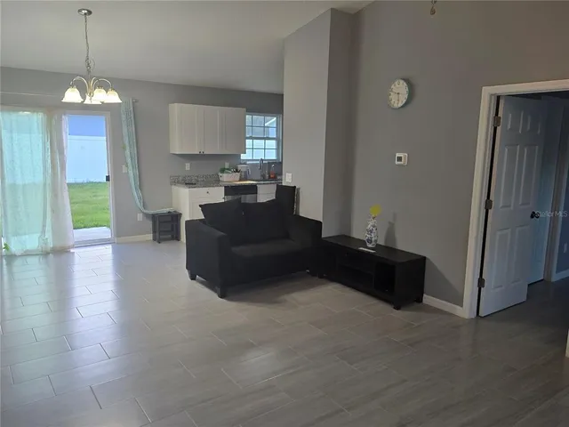 a living room with furniture and a chandelier