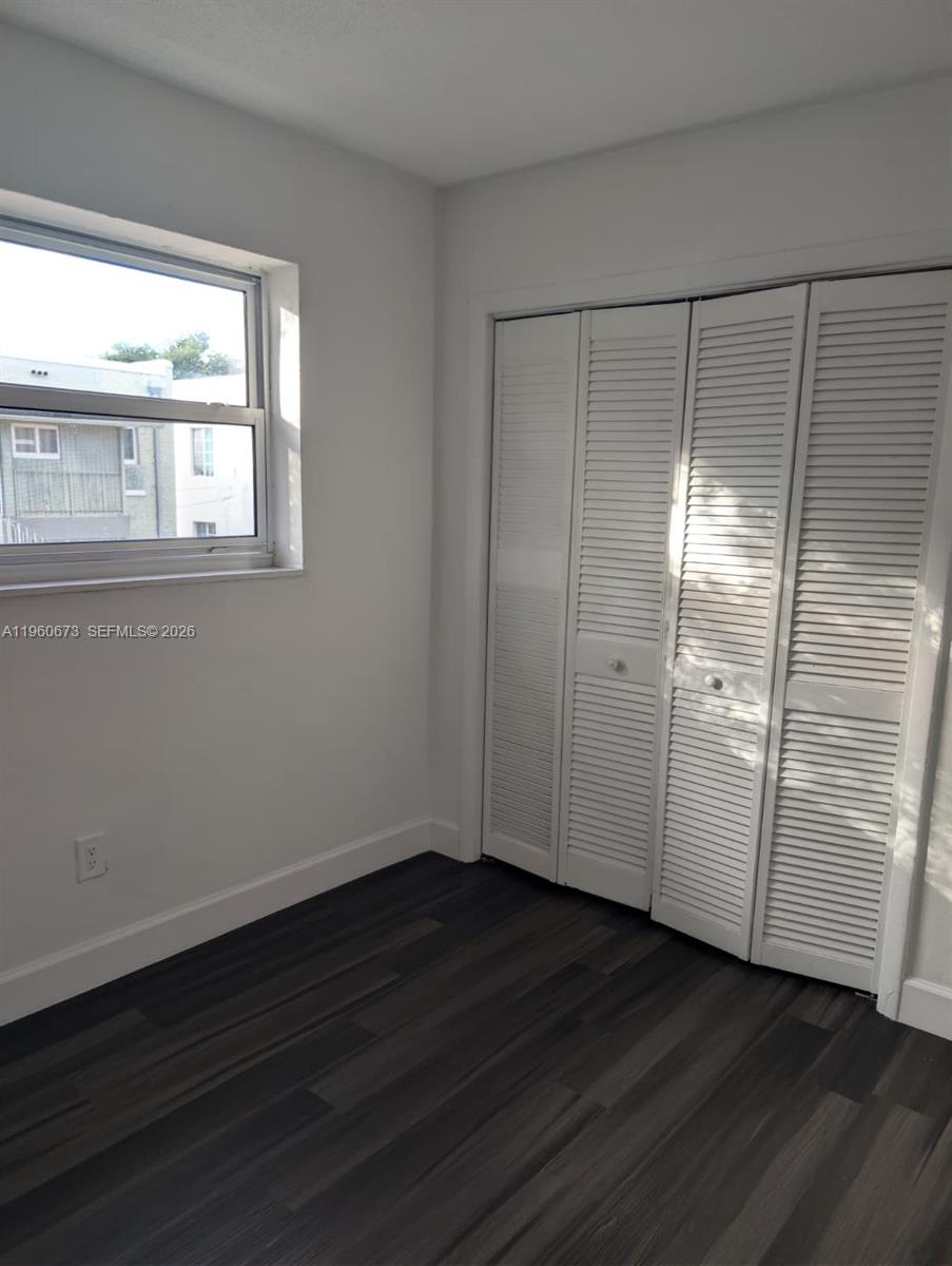 1461 Southwest 5th Street, Unit 2 Miami, FL 33135 - Photo 8 of 16 a view of an empty room with wooden floor and a window