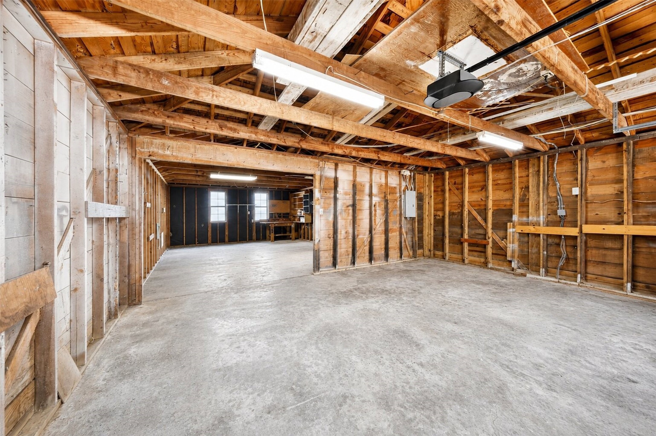 6507 Spring Leaf Drive Spring, TX 77379 - Photo 42 of 50 Massive detached three car garage featuring open beam ceilings, durable concrete floors, overhead lighting, and an attached workspace!