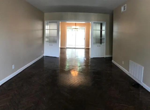a view of a room with wooden floor and a ceiling fan