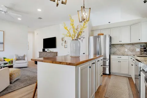 a kitchen with stainless steel appliances granite countertop a sink a stove and a refrigerator