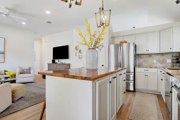 a kitchen with stainless steel appliances granite countertop a sink a stove and a refrigerator