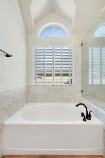 a bathroom with bathtub next to a window