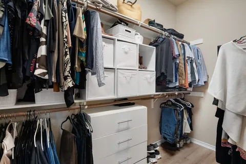 a view of walk in closet with clothes and shoes