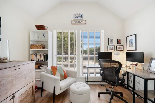a view of a workspace with furniture and a window