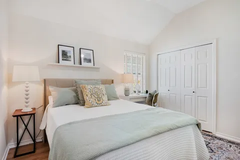 a bedroom with a large bed and a chandelier