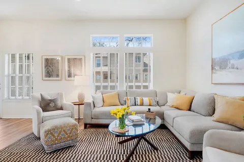 a living room with furniture a rug and a table
