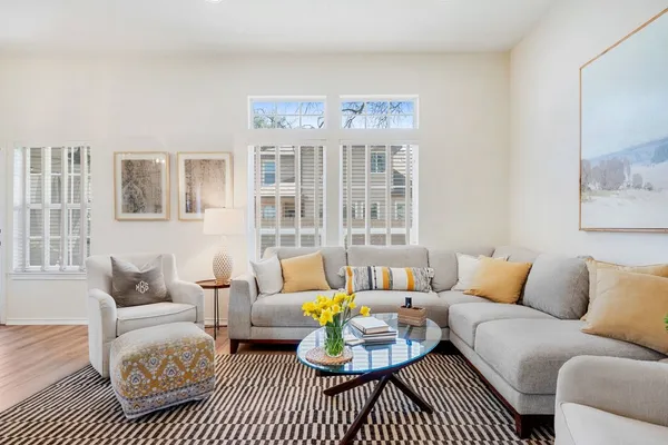 a living room with furniture a rug and a table