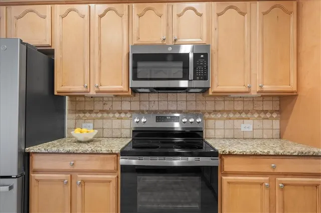 a kitchen with stainless steel appliances granite countertop a stove and a microwave