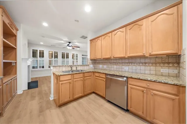 a kitchen with stainless steel appliances granite countertop a stove a sink dishwasher and a refrigerator
