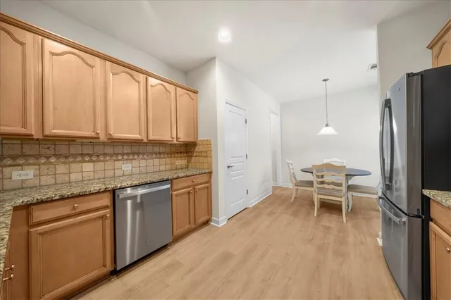 a kitchen with stainless steel appliances granite countertop a stove top oven a sink dishwasher and a refrigerator