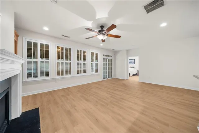 a view of an empty room with a window and a kitchen