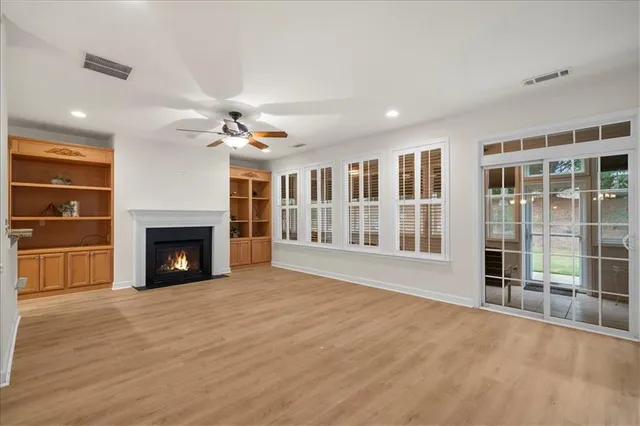 a view of an empty room with a fireplace and a window