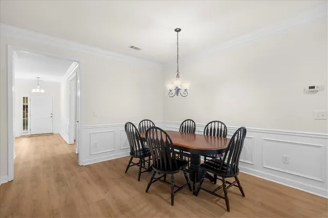 a view of a dining room with furniture wooden floor and chandelier
