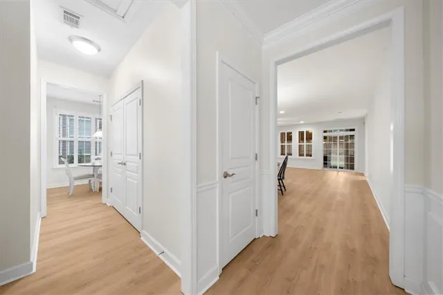 a view of a hallway with wooden floor and a living room