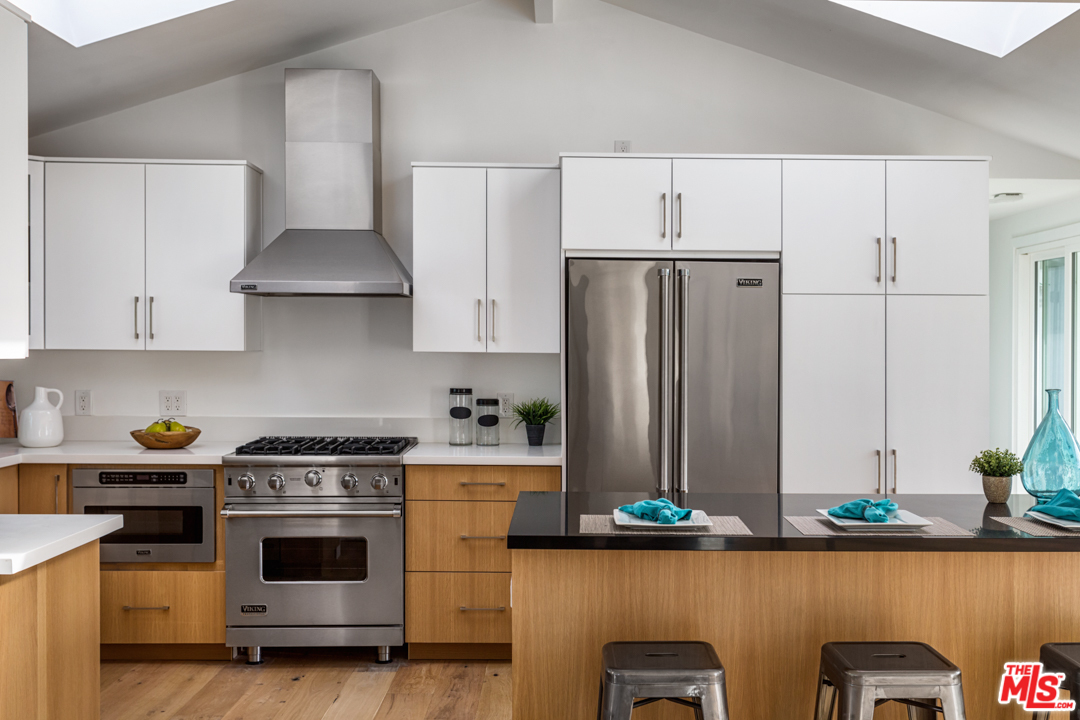 2048 Commodore Road Newport Beach, CA 92660 - Photo 12 of 39 a kitchen with stainless steel appliances a stove a refrigerator and cabinets